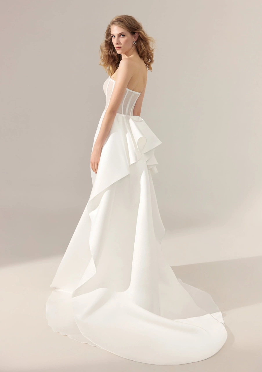 Abito da sposa particolare con corsetto steccato effetto nude e stecche a contrasto, gonna drappeggiata con spacco a portafoglio, strascico staccabile drappeggiato