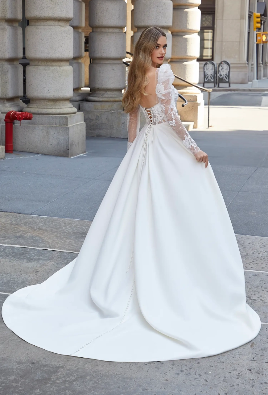 Abito da sposa particolare scivolato con maniche lunghe a sbuffo in tulle e picco, corpino con scollo a cuore in pizzo effetto tattoo, gonna liscia a portafoglio in crepe | Lo Specchio Atelier Abiti da Sposa a Verona