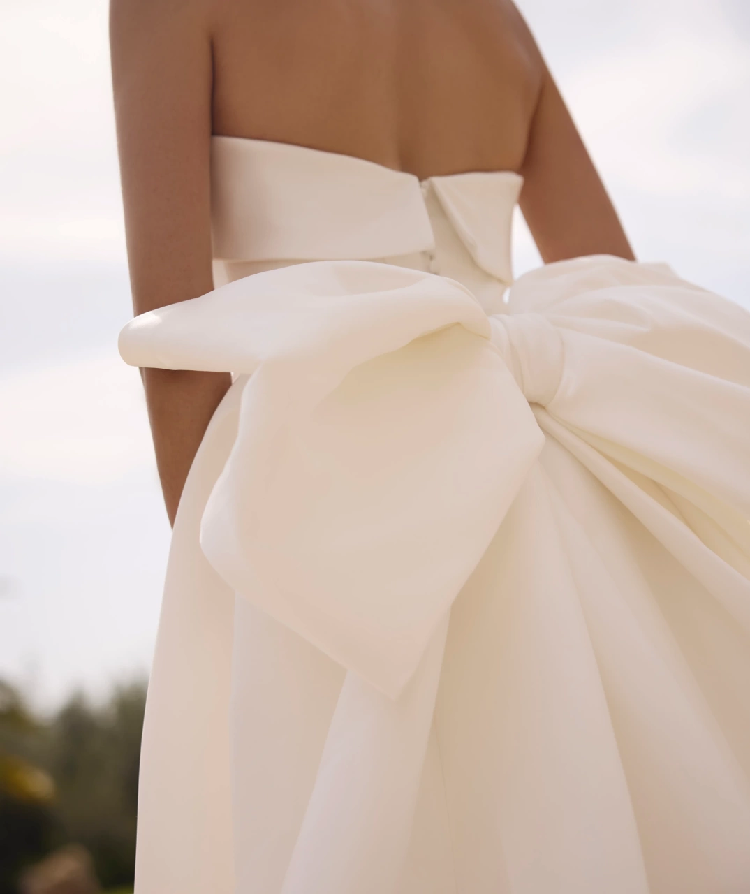 Abito da sposa semplice aderente con scollo dritto senza spalline, spacco laterale, voluminoso fiocco staccabile sul retro