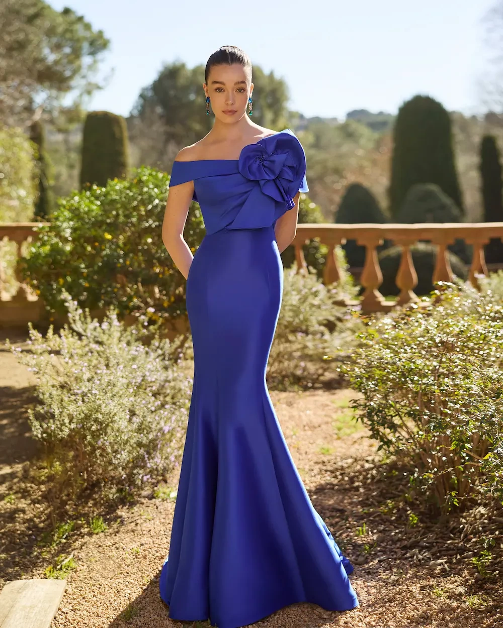 Abito lungo da cerimonia blu a sirena in mikado leggero con scollo scenografico off-sholder che si chiude sulla spalla sinistra con ruches voluminose, corpino leggermente drappeggiato - Lo Specchio Atelier Abiti da Cerimonia a Verona