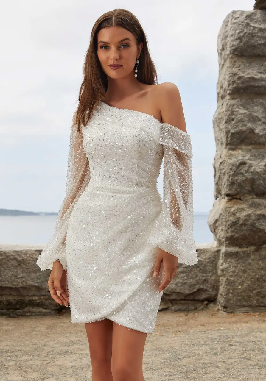 Vestito da sposa corto monospalla asimmetrico con maniche lunghe a palloncino in tulle, corpino drappeggiato in tulle, gonna a portafoglio in tulle drappeggiato, strass e brillanti su tutta la silhouette