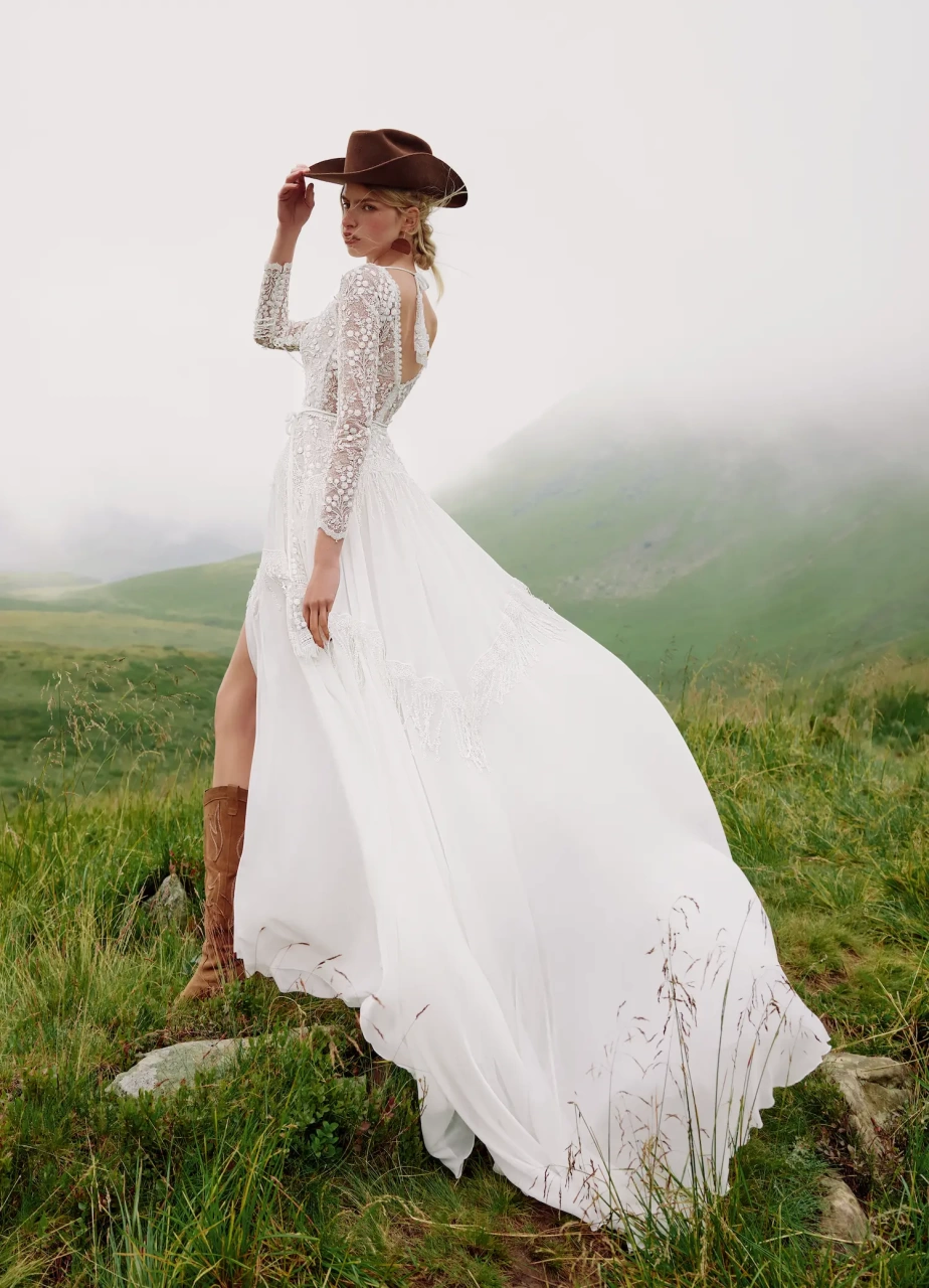 Abito da sposa particolare stile country chic con maniche lunghe effetto tattoo, scollo a barchetta, gonna scivolata con spacco e frange particolari applicate sulle maniche e sulla gonna | Lo Specchio Atelier Abiti da Sposa a Verona