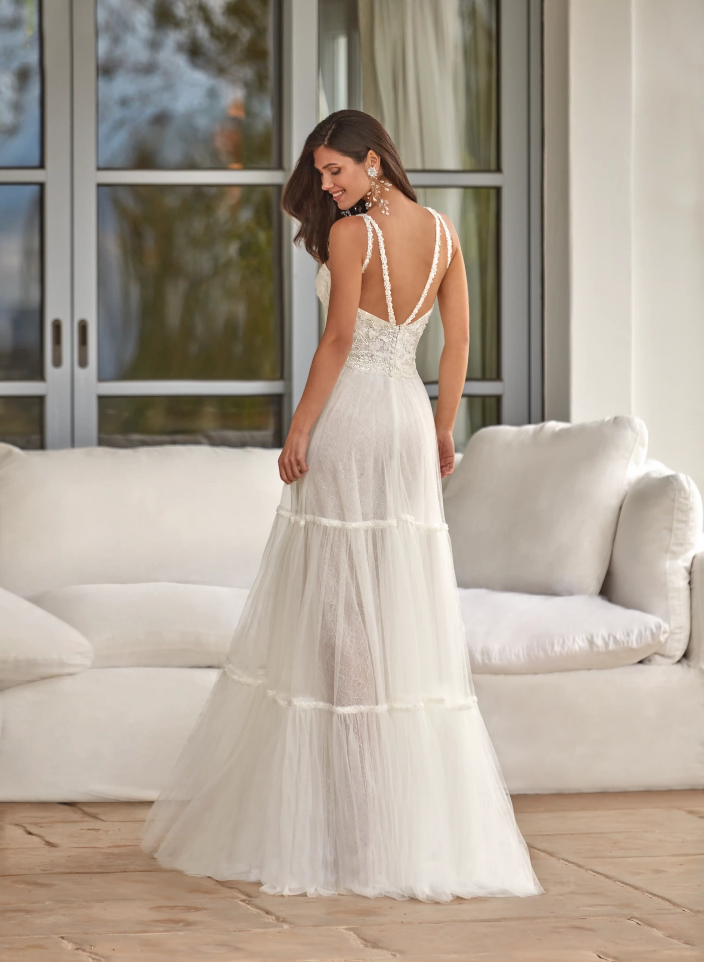 Abito da sposa romantico stile boho in pizzo e tulle, profondo scollo a V con spalline sottili, gonna a balze A-line scivolata leggera semi trasparente
