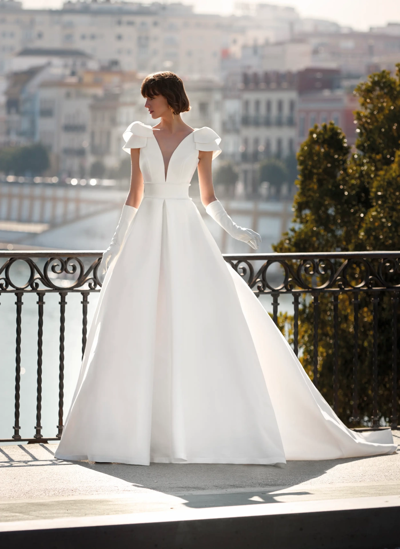 Abito da sposa semplice e lussuoso A-line in mikado con maniche corte ad aletta, profondo scollo a V, gonna strutturata con singola pince frontale | Lo Specchio Atelier Abiti da Sposa a Verona