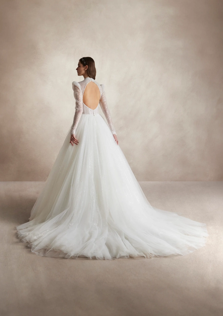 Abito da sposa lussuoso da principella con maniche lunghe a sbuffo in tulle, collo alto, corsetto strutturato con stecche e coppe a vista, gonna ampia A-line in tulle, pizzo ricamato con perle strass e cristalli su tutta la silhouette | Lo Specchio Atelier Abiti da Sposa a Verona