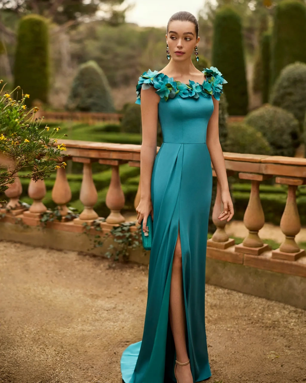 Abito da cerimonia a sirena verde con piccolo drappeggio sulla gonna e spacco sopra al ginocchio, strascico corto, scollo a barchetta con applicazioni 3D di fiori e foglie ton-sur-ton lungo tutta la linea dello scollo sia anteriore che posteriore - Lo Specchio Atelier Abiti da Cerimonia a Verona