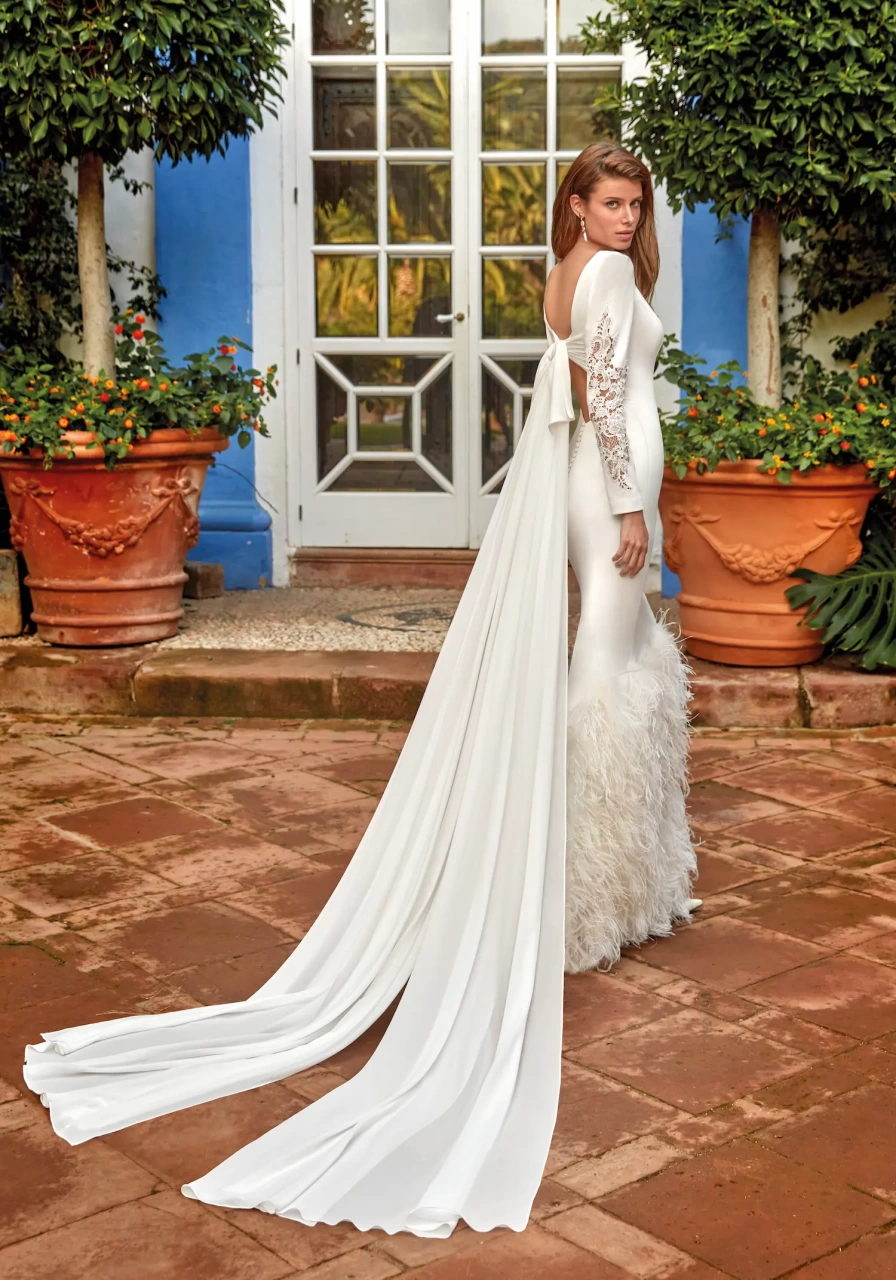 Abito da sposa particolare a sirena in mikado con maniche lunghe con applicazioni in pizzo, scollo a barchetta, gonna con elegante lavorazione di piume, strascico staccabile in chiffon
