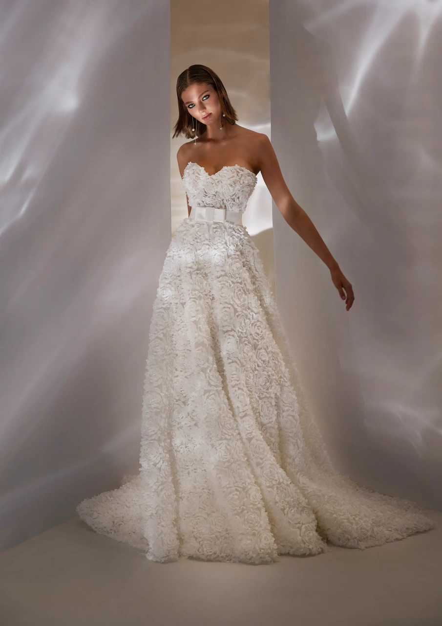 Vestito da sposa unico e particolare con fiori 3D realizzati su tutta la silhouette, scollo a cuore senza spalline, gonna scivolata, cintura in raso con fiocco geometrico | Lo Specchio Atelier Vestiti da Sposa a Verona