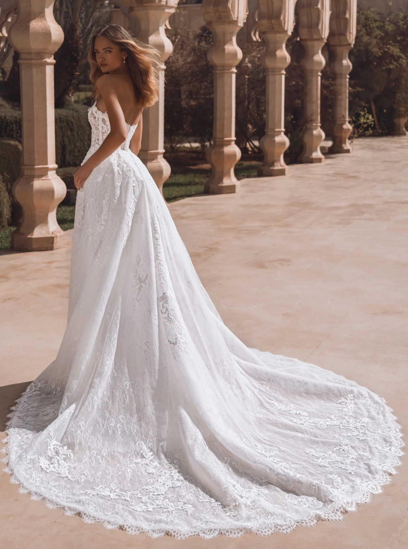 Abito da sposa a sirena in pizzo con corsetto effetto tattoo a vita basca, senza spalline, gonna staccabile con strascico voluminosa in tulle e pizzo