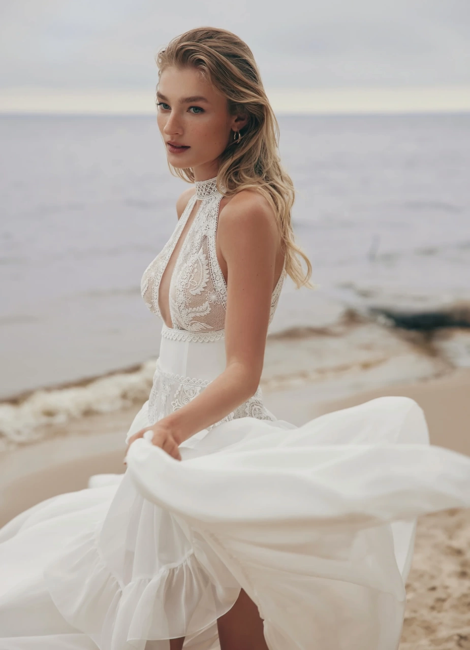 Abito da sposa boho romantico in pizzo effetto tatto con scollo all'americana e collo alto, bustino strutturato in mikado, gonna scivolata in tulle con pizzola balza sui fianchi