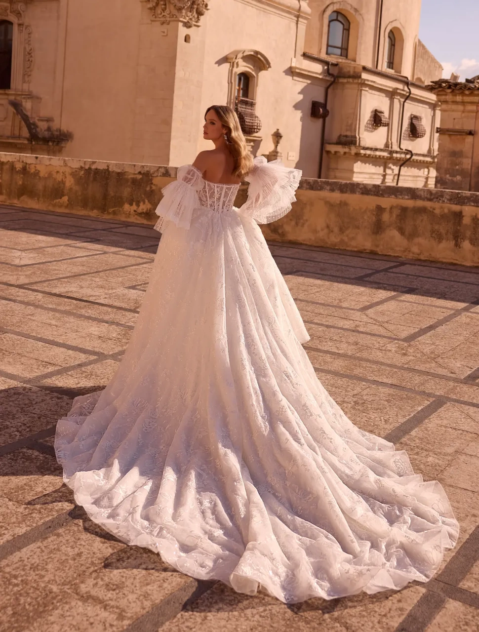 Abito da sposa boho romantico in pizzo con maniche lunghe particolare a balze di tulle, corsetto in pizzo effetto tattoo con stecche a vista, gonna A-line in tulle e pizzo | Lo Specchio Atelier Abiti da Sposa a Verona