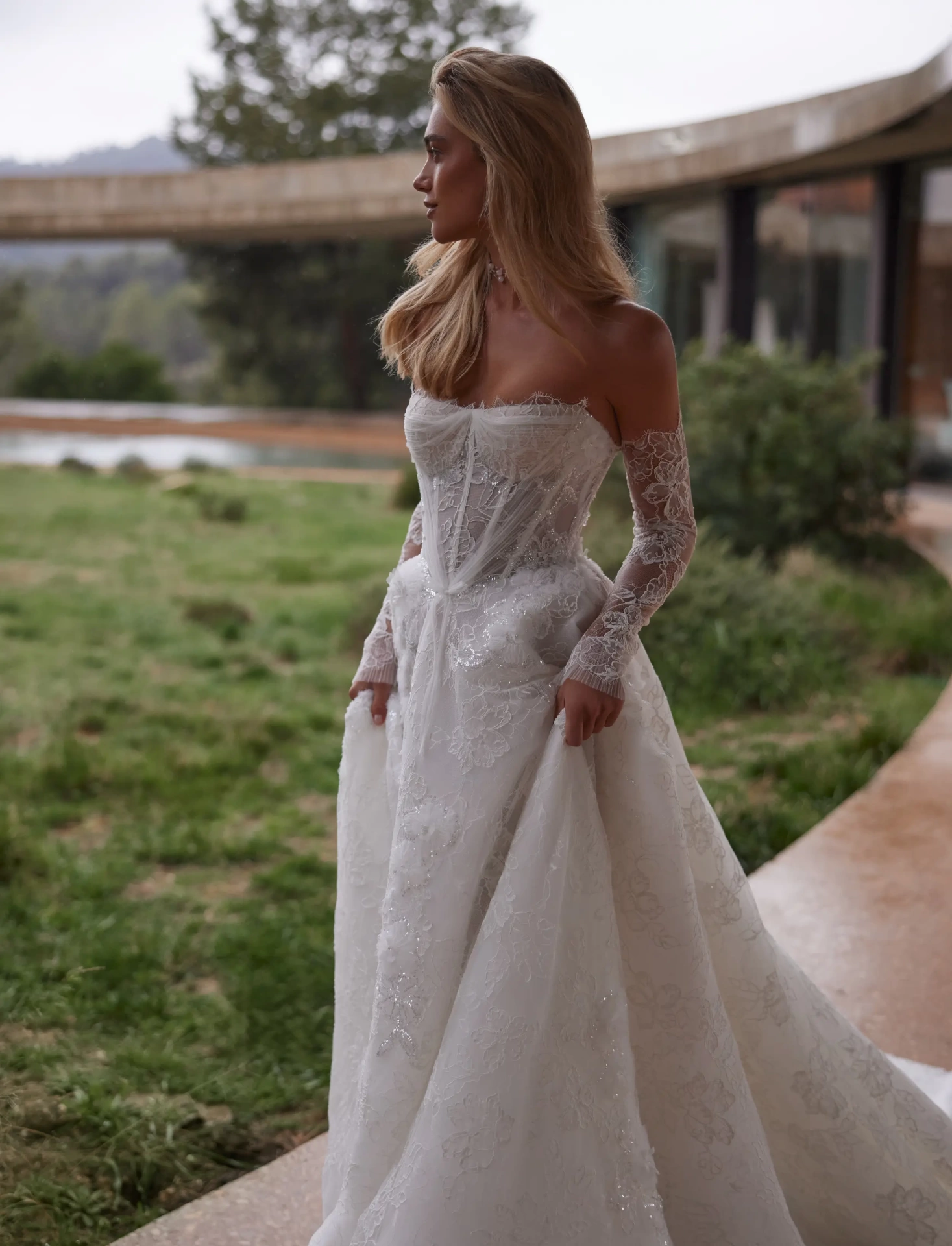 Abito da sposa con maniche lunghe off-shoulder separate in pizzo effetto tattoo, silhouette da principessa con gonna A-line in tulle e pizzo floreale, scollo a cuore, corpino a vita basca con stecche in vista, senza spalline