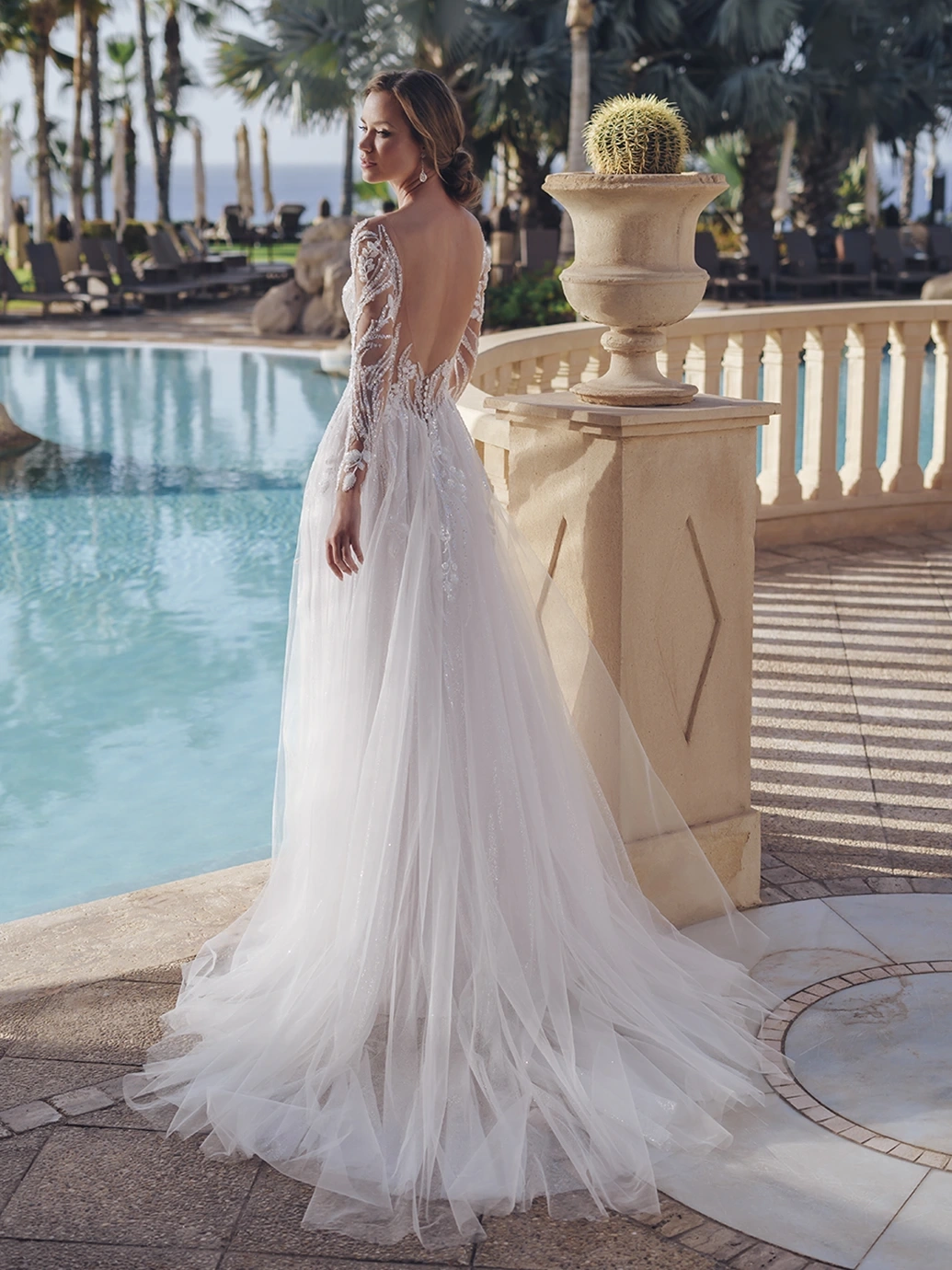 Abito da sposa particolare scivolato con maniche lunghe off-shoulder effetto tattoo, corpino in pizzo floreale effetto tattoo con glitter e cristalli, profondo scollo a V, gonna scivolata in tulle drappeggiato e glitterato con applicazioni di pizzo | Lo Specchio Atelier Abiti da Sposa a Verona