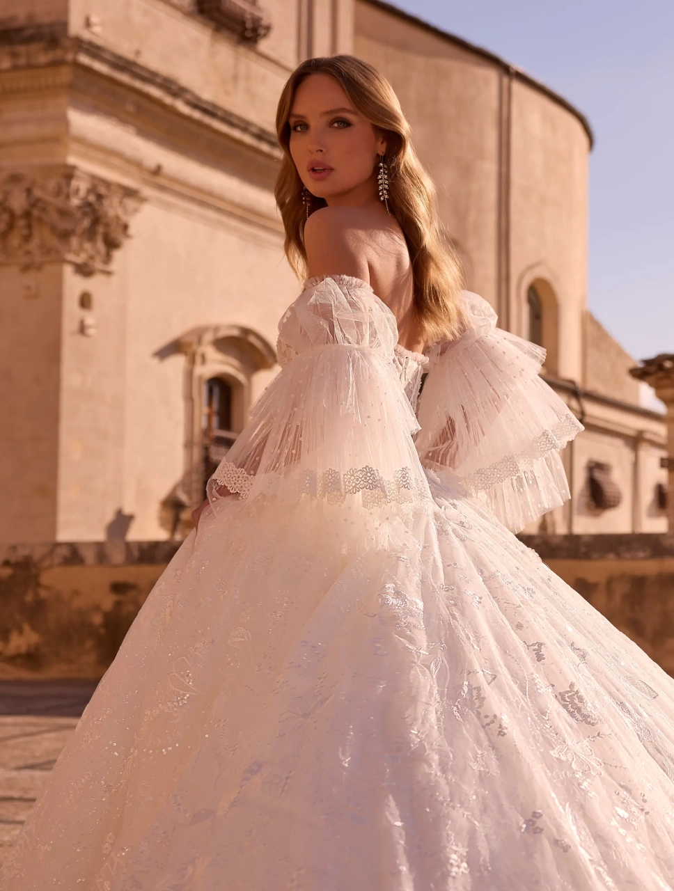 Abito da sposa boho romantico in pizzo con maniche lunghe particolare a balze di tulle, corsetto in pizzo effetto tattoo con stecche a vista, gonna A-line in tulle e pizzo | Lo Specchio Atelier Abiti da Sposa a Verona