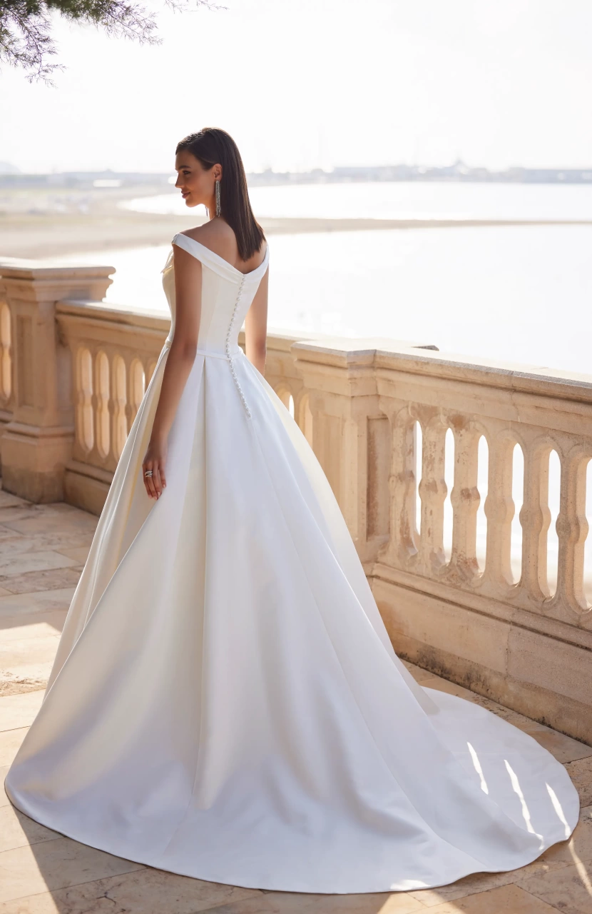 Vestito da sposa semplice elegante e raffinato A-line in mikado, gonna ampia strutturata, scollo off-shoulder con piccolo drappeggio che forma un fiocco sulla spallina sinistra | Lo Specchio Atelier Vestiti da Sposa a Verona
