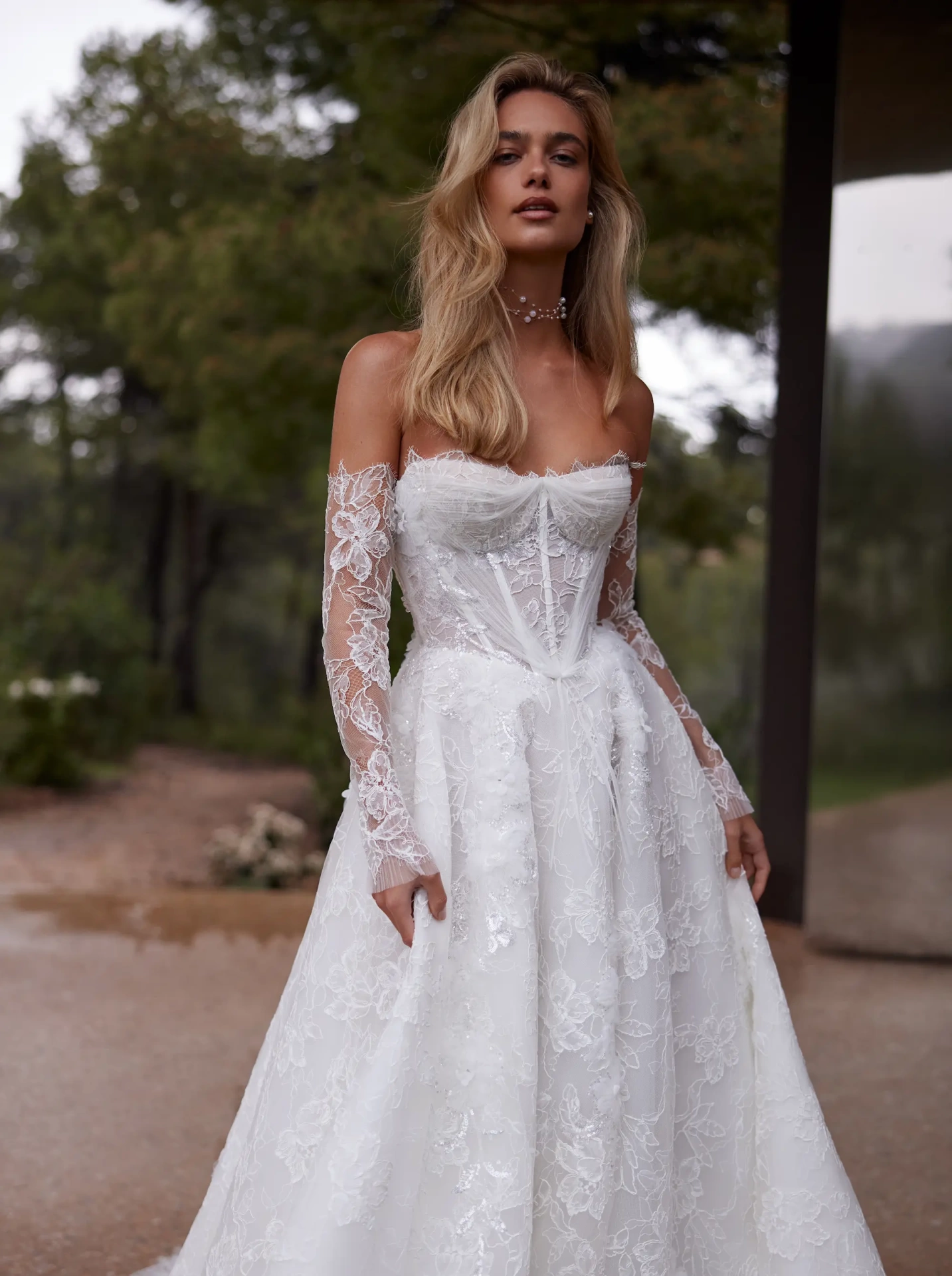 Abito da sposa con maniche lunghe off-shoulder separate in pizzo effetto tattoo, silhouette da principessa con gonna A-line in tulle e pizzo floreale, scollo a cuore, corpino a vita basca con stecche in vista, senza spalline