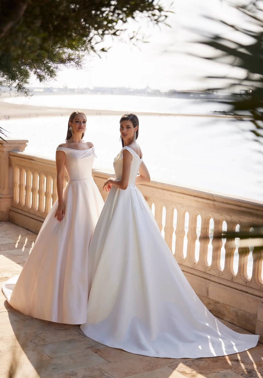 Vestito da sposa semplice elegante e raffinato A-line in mikado, gonna ampia strutturata, scollo off-shoulder con piccolo drappeggio che forma un fiocco sulla spallina sinistra | Lo Specchio Atelier Vestiti da Sposa a Verona