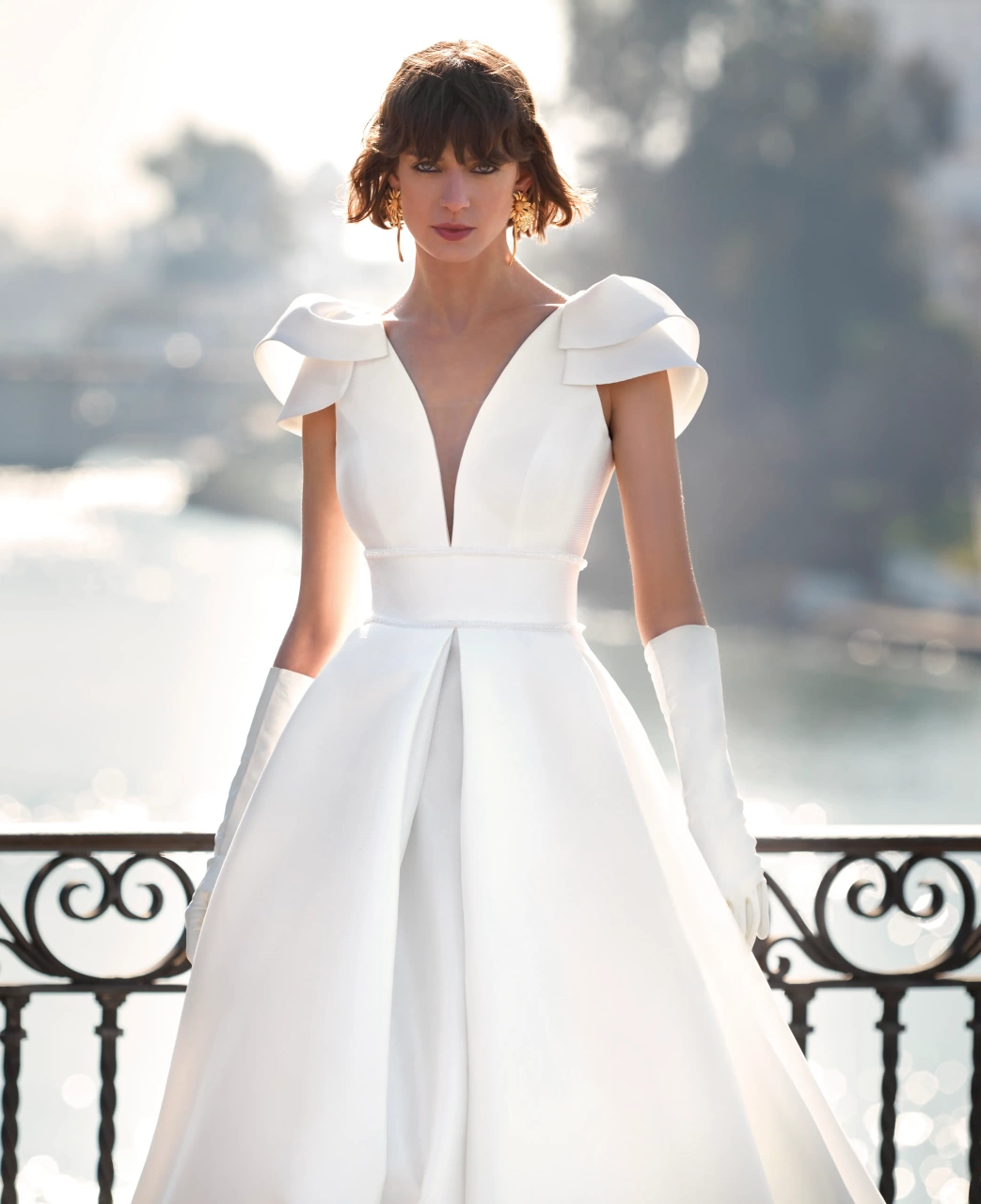 Abito da sposa semplice e lussuoso A-line in mikado con maniche corte ad aletta, profondo scollo a V, gonna strutturata con singola pince frontale | Lo Specchio Atelier Abiti da Sposa a Verona