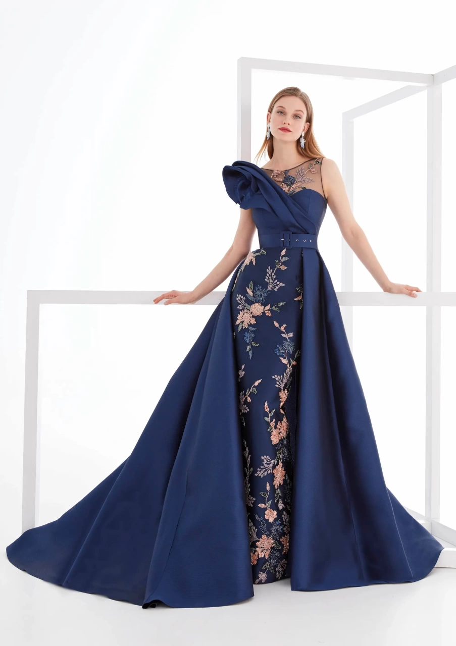 Vestito da cerimonia lungo estivo da donna color blu navy, gonna a sirena con stampa floreale rosa antico, sovragonna ampia e strutturata blu navy, cintura sul punto vita, scollo a barchetta velato e bustino con scollo a cuore e scenografico dettaglio 3D sulla spalla destra - Lo Specchio Atelier Abiti da Cerimonia a Verona