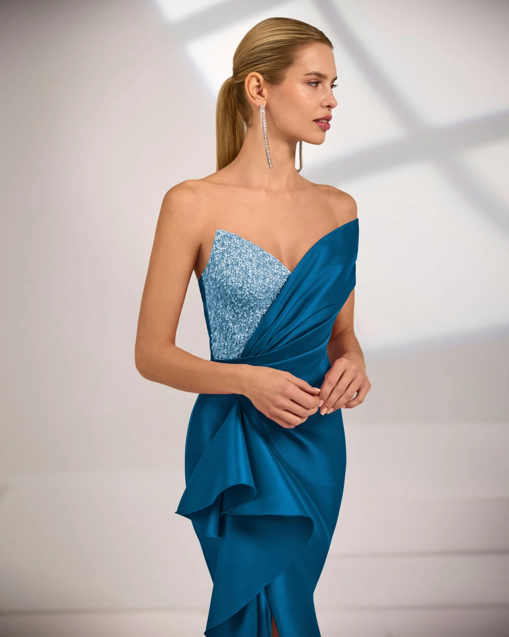 Abito da cerimonia estivo lungo a sirena color petrolio, bustino con dettaglio gioiello, scollo a cuore con singola manica off-shoulder, punto vita drappeggiato e morbido drappeggio 3D lungo il fianco - Lo Specchio Atelier Abiti da Cerimonia a Verona