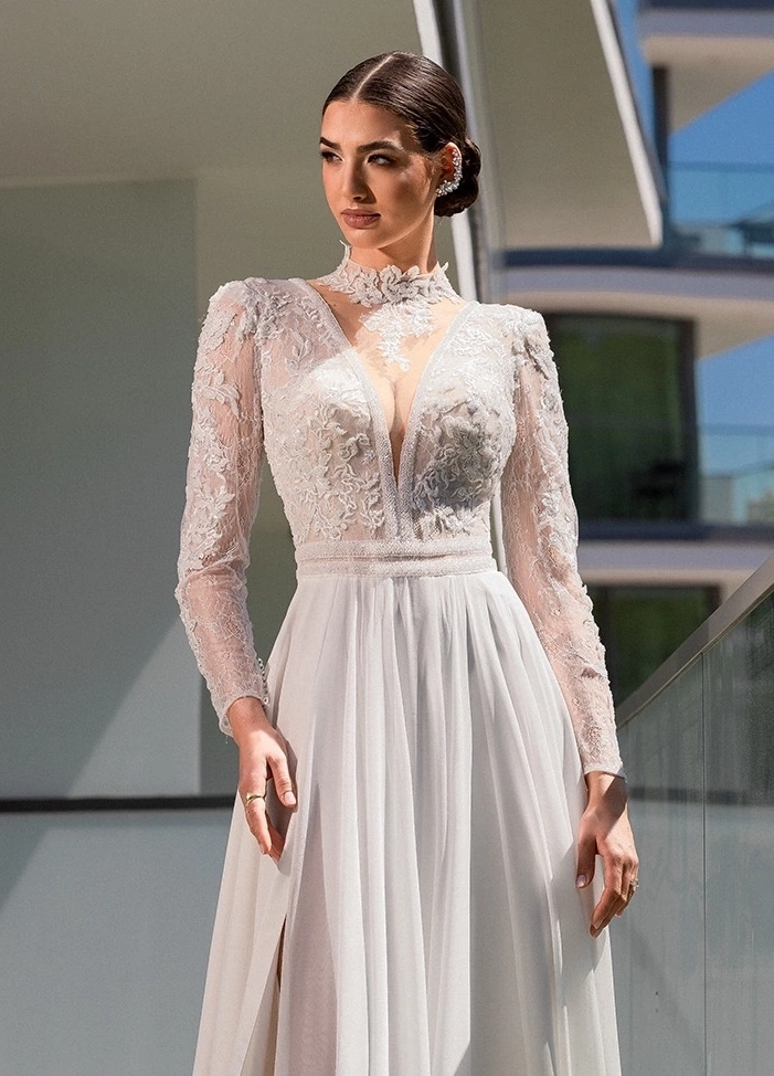 Abito da sposa da principessa lussuoso con maniche lunghe e bustino in pizzo effetto tattoo, schiena scoperta, profondo scollo a V, collo alto effetto tattoo, gonna scivolata morbida in chiffon | Lo Specchio Atelier Abiti da Sposa a Verona