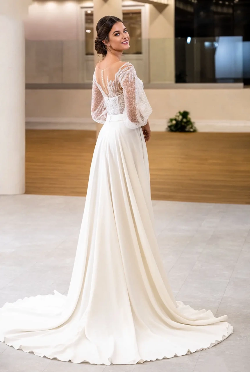 Abito da sposa con maniche lunghe in tulle a palloncino, corsetto con stecche a vista in pizzo effetto tattoo, gonna scivolata in morbida organza con spacco | Lo Specchio Atelier Abiti da Sposa a Verona