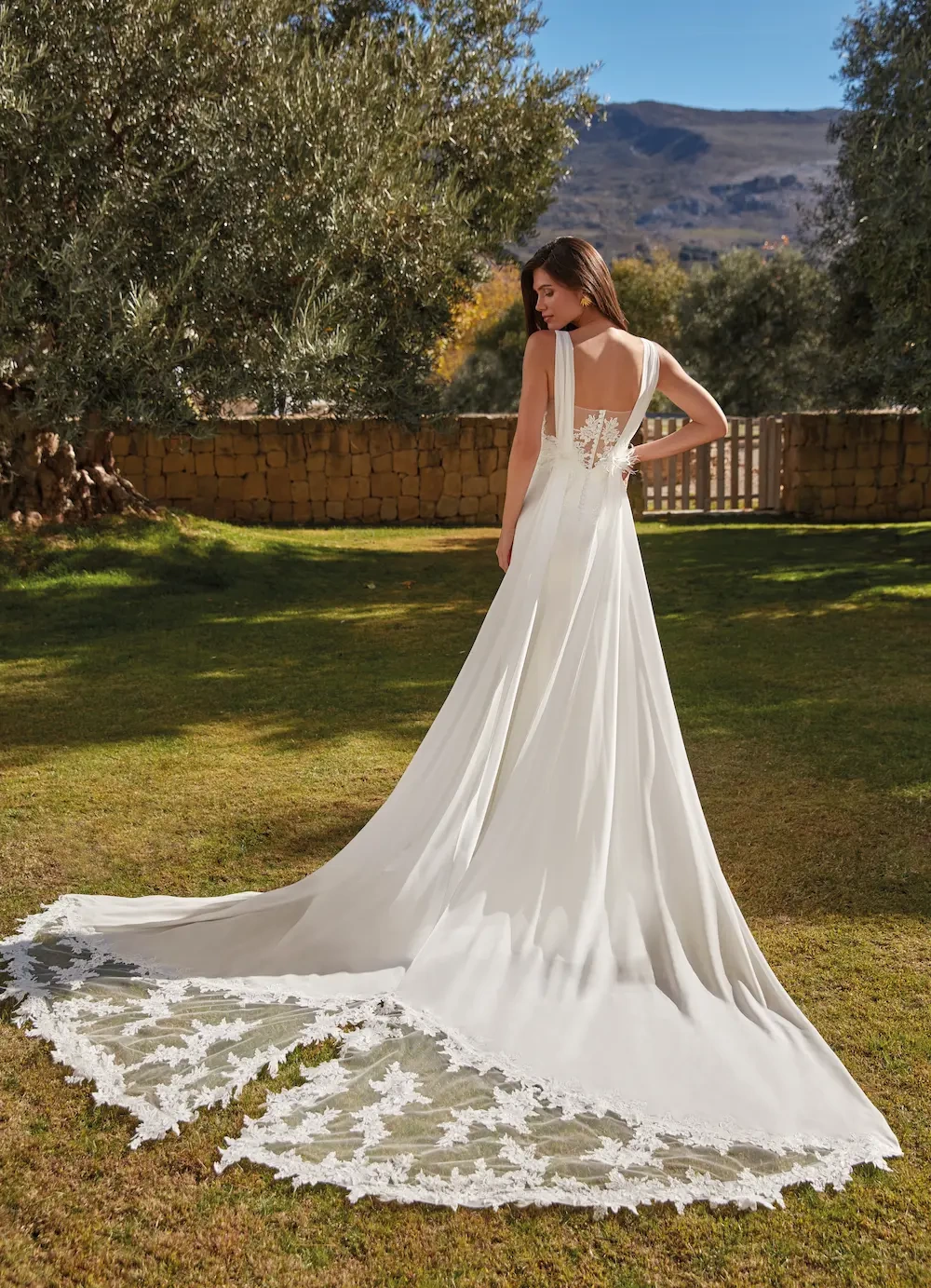 Abito da sposa semplice con scollo a barchetta e schiena scoperta con dettaglio in pizzo effetto tattoo, linea morbida a sirena, strascico removibile in pizzo