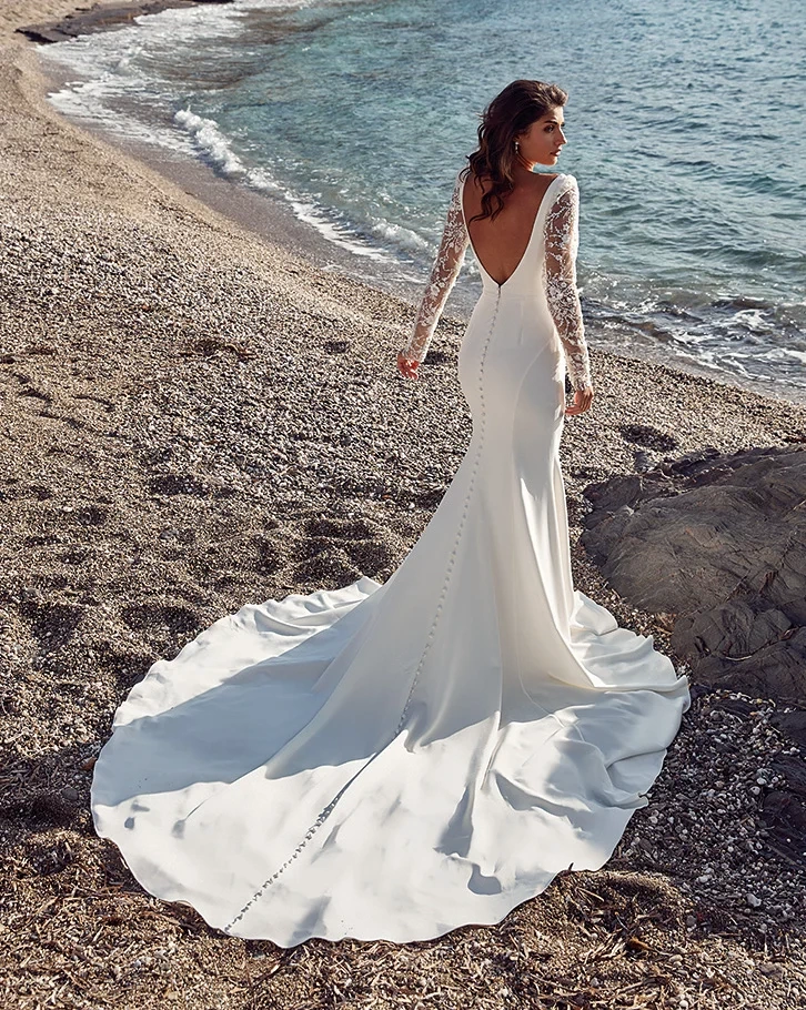 Vestito da sposa a sirena in crepe con maniche lunghe effetto tattoo in pizzo, profondo scollo a V velato, schiena scoperta