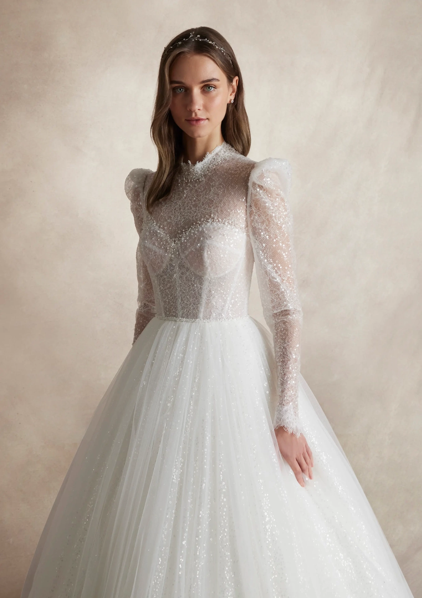 Abito da sposa lussuoso da principella con maniche lunghe a sbuffo in tulle, collo alto, corsetto strutturato con stecche e coppe a vista, gonna ampia A-line in tulle, pizzo ricamato con perle strass e cristalli su tutta la silhouette | Lo Specchio Atelier Abiti da Sposa a Verona