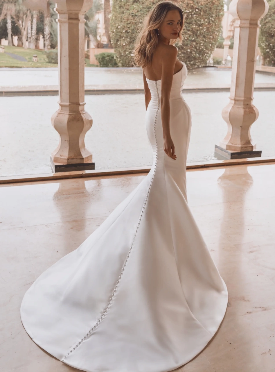 Abito da sposa semplice a sirena in mikado con drappggio sul bustino e sul fianco, scollo a cuore, strascico staccabile particolare con drappeggio che crea una voluminosa rosa 3D