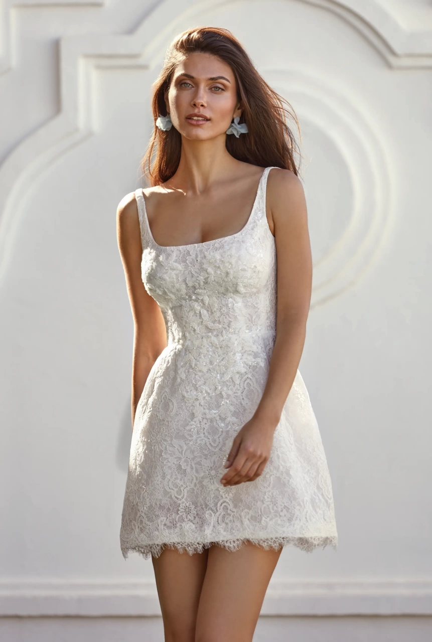 Vestito da sposa corto in pizzo con scollo squadrato e spalline spesse, gonna staccabile ampia e strutturata in mikado con fiocco frontale in pizzo