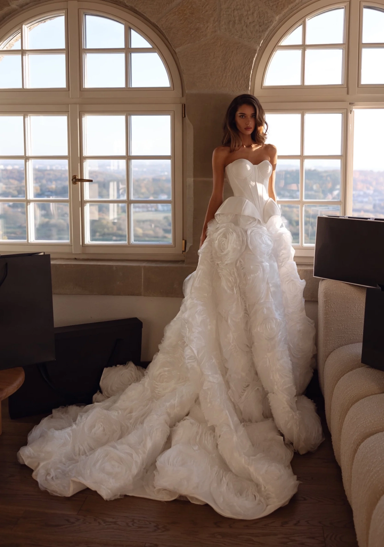 Abito da sposa particolare e scenografico con corpetto steccato in mikado, scollo a cuore senza spalline, fianchi strutturati e gonna particolare con rose 3D in tulle