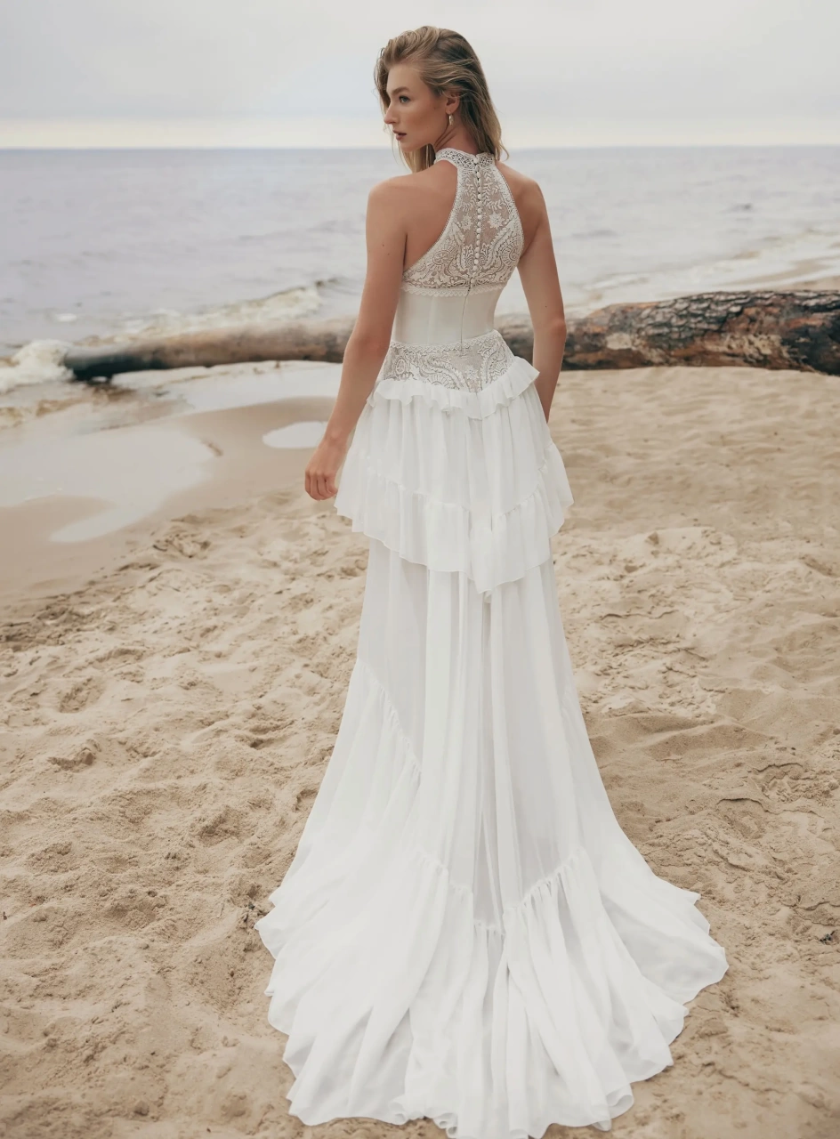 Abito da sposa boho romantico in pizzo effetto tatto con scollo all'americana e collo alto, bustino strutturato in mikado, gonna scivolata in tulle con pizzola balza sui fianchi