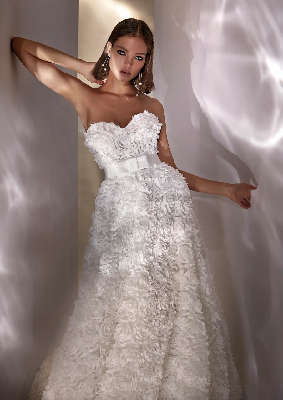Vestito da sposa unico e particolare con fiori 3D realizzati su tutta la silhouette, scollo a cuore senza spalline, gonna scivolata, cintura in raso con fiocco geometrico | Lo Specchio Atelier Vestiti da Sposa a Verona