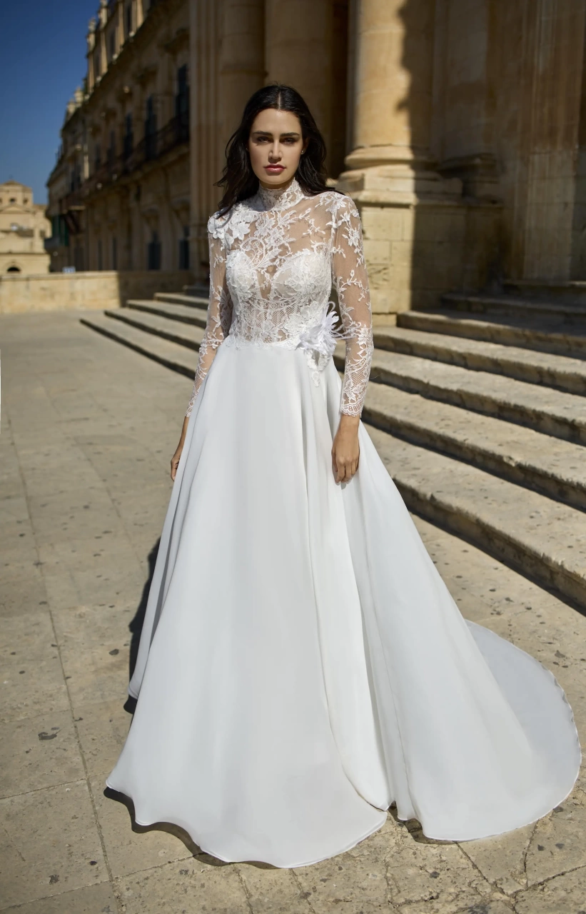Vestito da sposa con maniche lunghe in pizzo floreale effetto tattoo, collo alto, corpetto steccato con scollo a cuore, dettaglio a fiore 3D sul fianco, gonna scivolata in organza morbida
