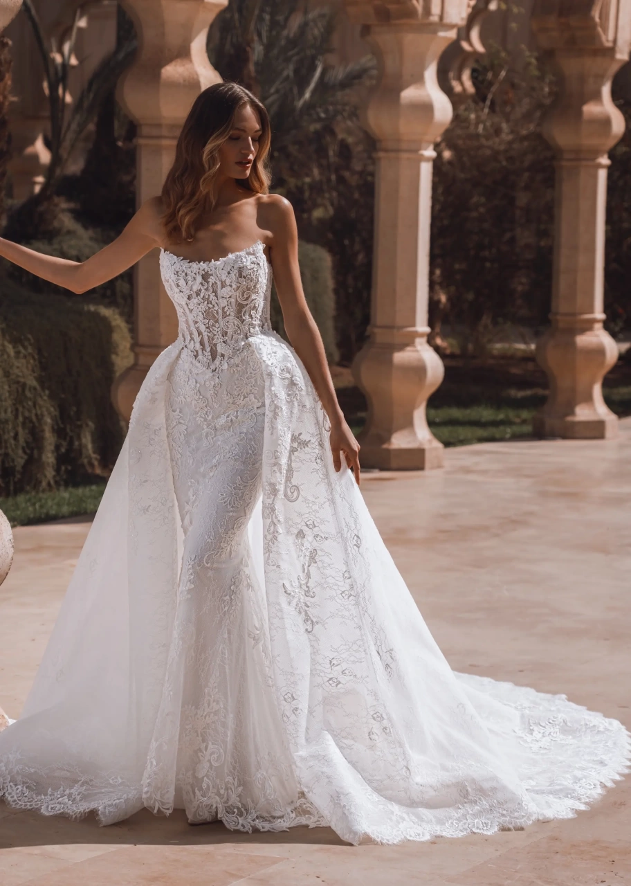 Abito da sposa a sirena in pizzo con corsetto effetto tattoo a vita basca, senza spalline, gonna staccabile con strascico voluminosa in tulle e pizzo