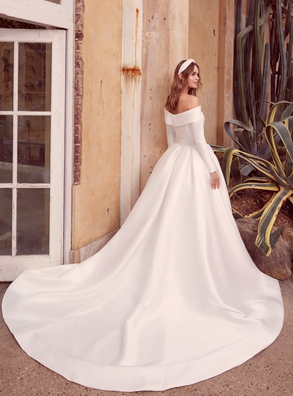 Abito da sposa semplice in mikado con scollo dritto off-shoulder, cintura con fibbia ton-sur-ton, maniche lunghe staccabili, gonna ampia strutturata | Lo Specchio Atelier Abiti da Sposa a Verona