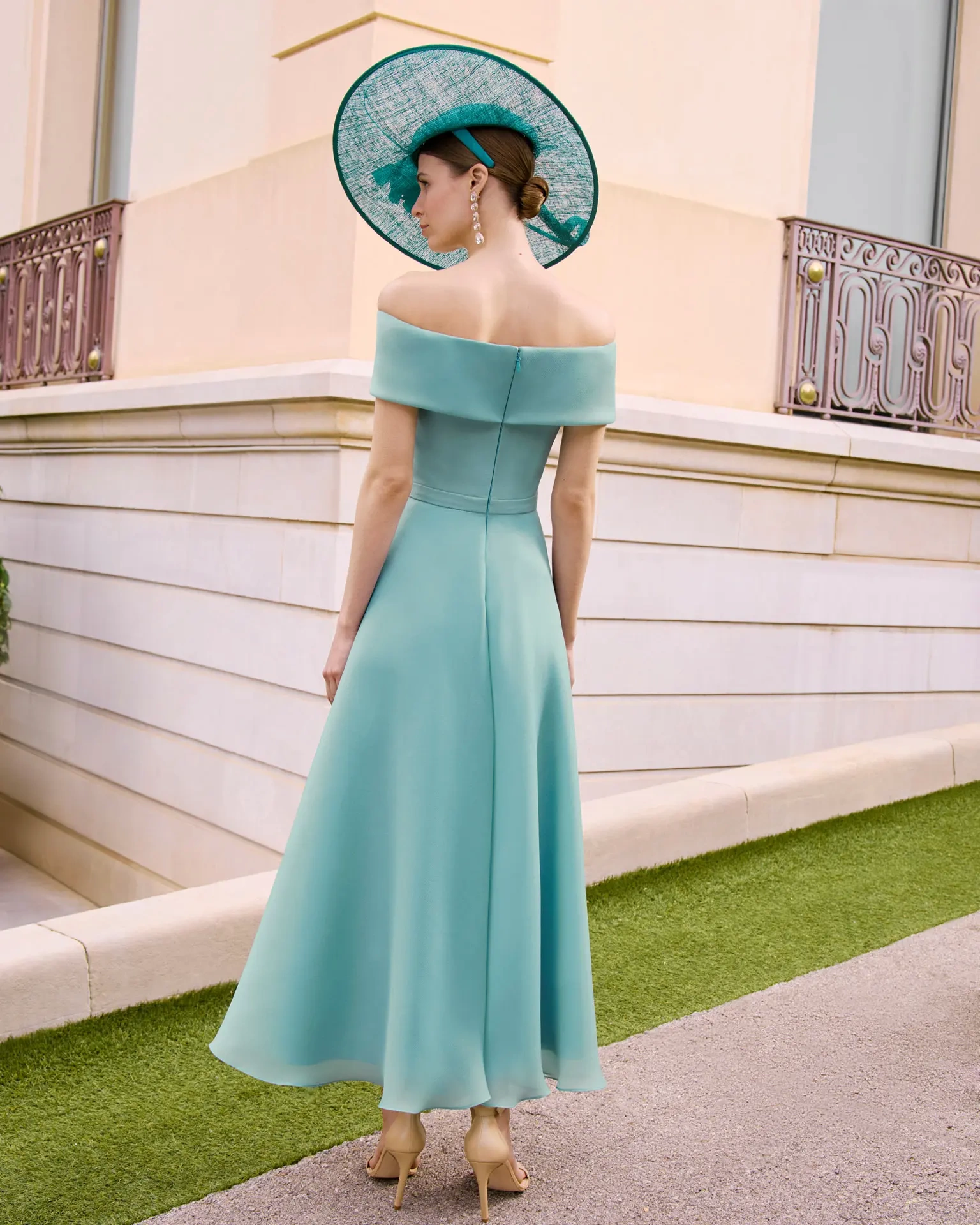 Abito da cerimonia azzurro midi per la mamma della sposa e dello sposo, elegante scollo off-shoulder, gonna scivolata morbida, cintura in vita con fiore 3D - Lo Specchio Atelier Abiti da Cerimonia a Verona