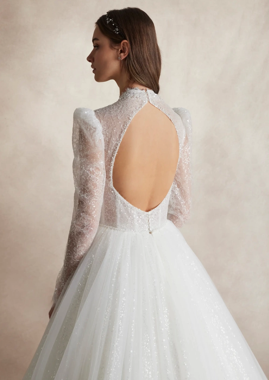 Abito da sposa lussuoso da principella con maniche lunghe a sbuffo in tulle, collo alto, corsetto strutturato con stecche e coppe a vista, gonna ampia A-line in tulle, pizzo ricamato con perle strass e cristalli su tutta la silhouette | Lo Specchio Atelier Abiti da Sposa a Verona