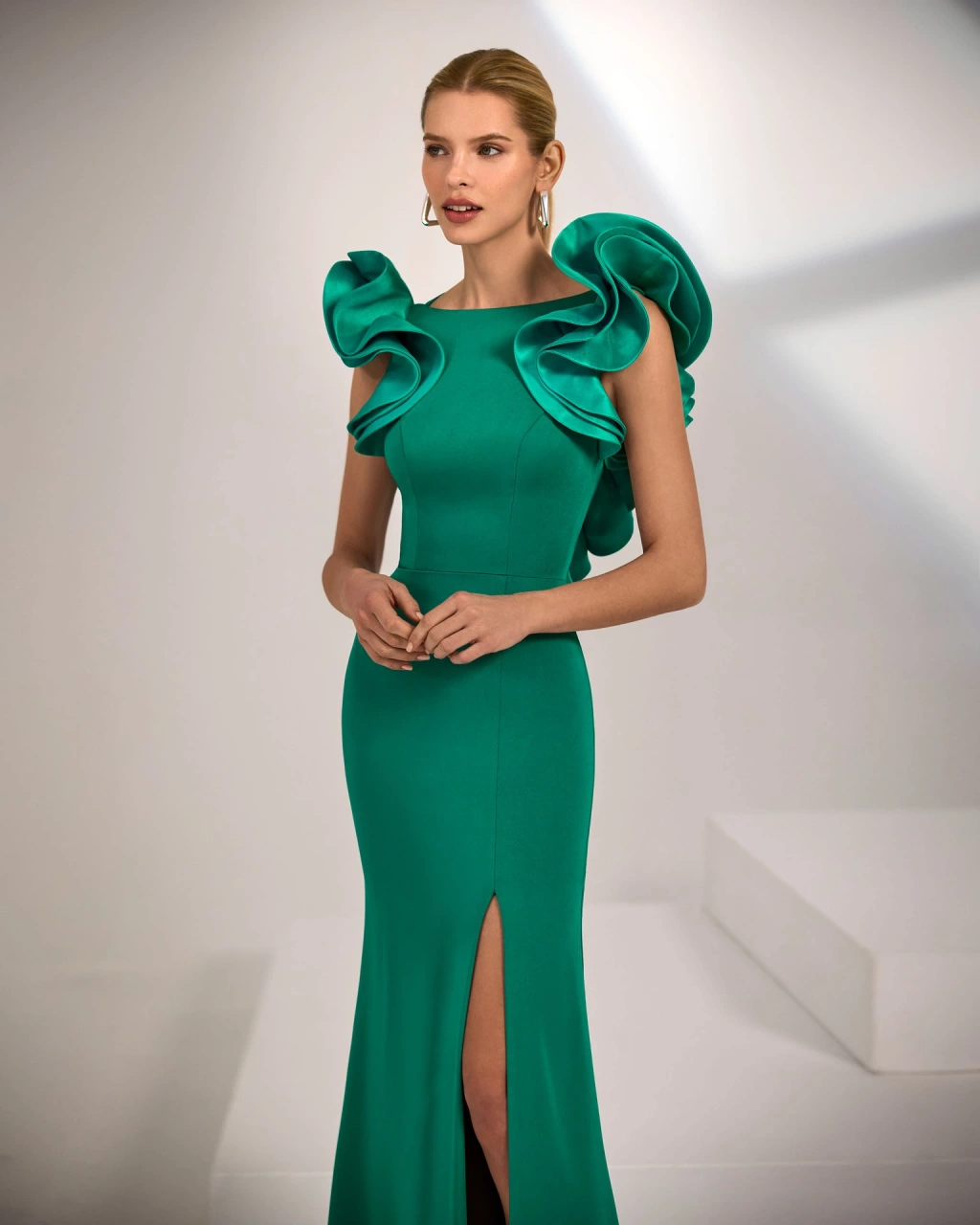 Abito lungo da cerimonia verde smeraldo a sirena in crëpe, scollo a barchetta e schiena scoperta, con un'applicazione di voluminose ruches lungo tutto lo scollo posteriore, gonna con spacco frontale - Lo Specchio Atelier Abiti da Cerimonia a Verona