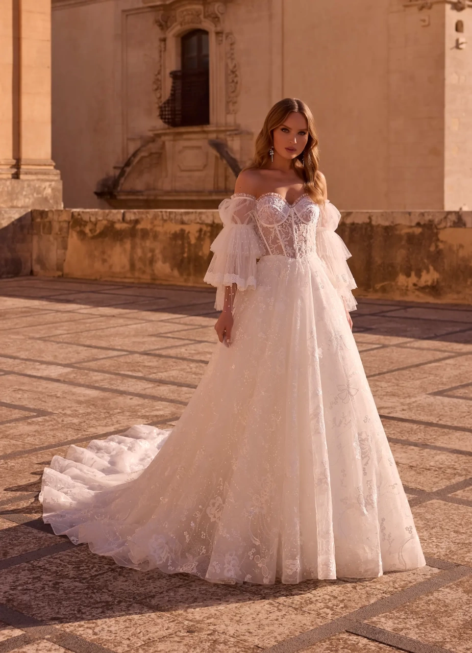 Abito da sposa boho romantico in pizzo con maniche lunghe particolare a balze di tulle, corsetto in pizzo effetto tattoo con stecche a vista, gonna A-line in tulle e pizzo | Lo Specchio Atelier Abiti da Sposa a Verona