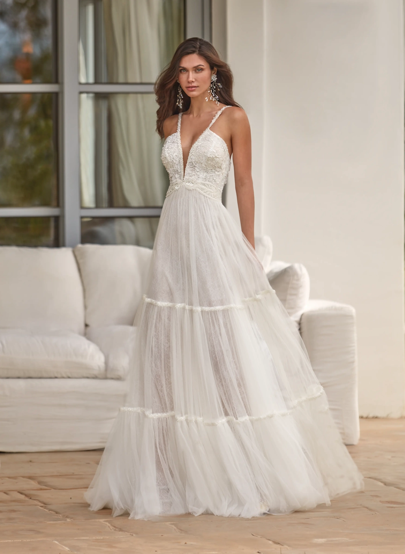 Abito da sposa romantico stile boho in pizzo e tulle, profondo scollo a V con spalline sottili, gonna a balze A-line scivolata leggera semi trasparente